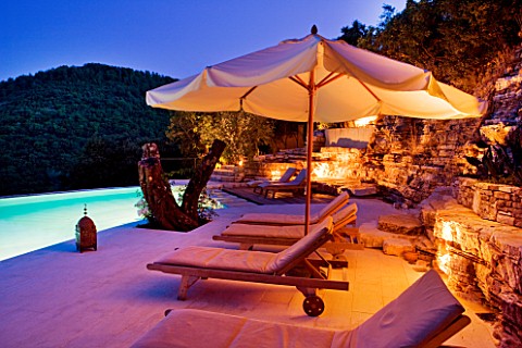 THE_ROU_ESTATE__CORFU__GREECE_DESIGNER_DOMINIC_SKINNER__THE_SWIMMING_POOL_AREA__LIT_UP_AT_NIGHT_WITH