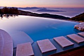 THE ROU ESTATE  CORFU - DESIGNER DOMINIC SKINNER - THE SWIMMING POOL AT DAWN WITH VIEWS OF THE ALBANIAN MOUNTAINS IN THE BACKGROUND