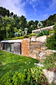 DESIGNER: JEAN-LAURENT FELIZIA  FRANCE: POOL HOUSE WITH LAWN AND SUCCULENTS GROWING ON THE ROOF