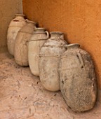 DESIGNERS ERIC OSSART AND ARNAUD MAURIERES  MOROCCO: AL HOSSOUN - TERRACOTTA JARS/ CONTAINERS AGAINST ORANGE WALL