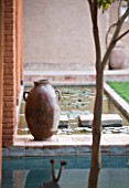 DESIGNERS ERIC OSSART AND ARNAUD MAURIERES  MOROCCO: AL HOSSOUN - TERRACOTTA CONTAINER BESIDE A WATER LILY POOL