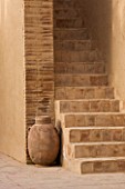 DESIGNERS ERIC OSSART AND ARNAUD MAURIERES  MOROCCO: AL HOSSOUN - TERRACOTTA CONTAINER BESIDE SOME STEPS