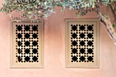 DESIGNERS ERIC OSSART AND ARNAUD MAURIERES  MOROCCO: AL HOSSOUN - ORNATE WOODEN WINDOWS IN PINK WALL