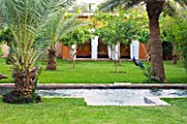 DESIGNERS ERIC OSSART AND ARNAUD MAURIERES  MOROCCO: AL HOSSOUN - FORMAL POOL ON LAWN WITH SUMMERHOUSE BHIND