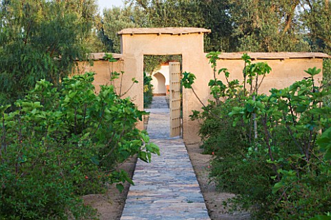 DESIGNERS_ERIC_OSSART_AND_ARNAUD_MAURIERES__MOROCCO_DAR_IGDAD__PATH_TO_GATE_IN_EARTH_WALL__ORCHARD_W