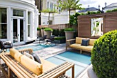 ROOF GARDEN AT GROUND LEVEL BY STEPHEN WOODHAMS, LONDON: TERRACE/SEATING AREA WITH WOODEN BENCHES, BOX BALLS IN CONTAINERS, DECKING WITH FROSTED GLASS SKYLIGHTS, SCREEN, MIRROR, DECKS, DECKING, DECKED
