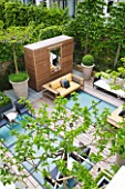 MODERN ROOF GARDEN BY STEPHEN WOODHAMS, LONDON: CEDARWOOD SCREEN, MIRROR, TABLE, CHAIRS, CLIPPED, TOPIARY, PLEACHED, HORNBEAMS, CONTEMPORARY, BOX BALLS IN CERAMIC CONTAINERS, CORNUS KOUSA, TERRACE, BALCONY. MULBERRY