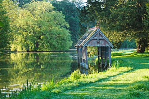 NARBOROUGH_HALL_GARDENS__NORFOLK_THE_RECENTLY_RESTORED__LISTED_BOAT_HOUSE_ON_THE_BANKS_OF_THE_RIVER_