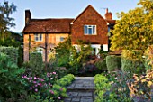 SANDHILL FARM HOUSE  HAMPSHIRE - DESIGNER ROSEMARY ALEXANDER: VIEW TO THE HOUSE ALONG A PATH EDGED WITH ALCHEMILLA MOLLIS AND ROSA GALLICA VERSICOLOR