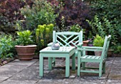 SANDHILL FARM HOUSE  HAMPSHIRE - DESIGNER ROSEMARY ALEXANDER - GREEN PAINTED WOODEN BENCH AND CHAIRS ON PATIO