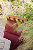 LONDON ROOFTOP GARDEN: WOODEN TABLE AND CHAIR ON WOODEN DECKING SURROUNDED BY STIPA TENUISSIMA  PHYLOSTACHYS AUREA AND NEPETA SIX HILLS GIANT
