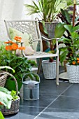 DESIGNER CLARE MATTHEWS - CONSERVATORY WITH METAL CHAIR AND VARIOUS CONTAINERS PLANTED WITH HERBS AND GERBERAS