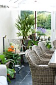 DESIGNER CLARE MATTHEWS - CONSERVATORY WITH METAL CHAIR  WICKER CHAIRS AND TABLE AND VARIOUS CONTAINERS
