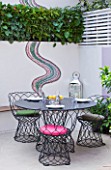 SMALL TOWN GARDEN  LONDON. DESIGNER - ANA SANCHEZ - MARTIN  OF GERMINATE DESIGN. PINK AND WHITE GARDEN WITH DECKING  TABLE AND CHAIRS  MOSAIC BY CELIA GREGORY. A PLACE TO SIT