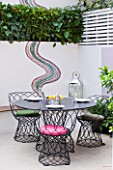 SMALL TOWN GARDEN  LONDON. DESIGNER - ANA SANCHEZ - MARTIN  OF GERMINATE DESIGN. PINK AND WHITE GARDEN WITH DECKING  TABLE AND CHAIRS  MOSAIC BY CELIA GREGORY. A PLACE TO SIT