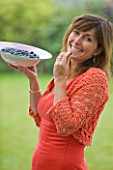 DESIGNER CLARE MATTHEWS: CLARE HOLDING A BOWL OF BLUEBERRIES AND ABOUT TO EAT A BLUEBERRY