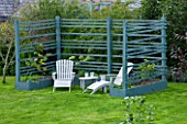 DESIGNER CLARE MATTHEWS: THE FRUIT AND VEGETABLE GARDEN IN DEVON. RAISED  BLUE PAINTED WOODEN BEDS AND ARBOUR WITH DECK CHAIRS