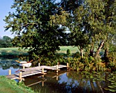 ANGUS WHITES JAPANESE BRIDGE OVER THE LAKE IN HIS GARDEN AT ARCHITECTURAL PLANTS  SUSSEX