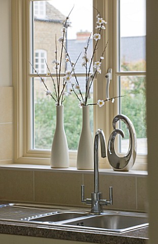 MODERN_KITCHEN_WITH_VIEW_OUT_OF_WINDOW_PAST_METAL_SINK_AND_TAPS