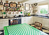 DESIGNER BUTTER WAKEFIELD  LONDON - THE KITCHEN WITH BOTANICAL PRINTS AND TABLE OF GREEN AND WHITE SQUARES MADE BY BUTTERS MOTHER-IN-LAW - FELICITY WAKEFIELD