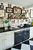 DESIGNER BUTTER WAKEFIELD  LONDON - THE KITCHEN WITH BOTANICAL PRINTS ON THE WALLS ABOVE THE COOKER