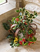 DESIGNER - JACKY HOBBS : CHRISTMAS DECORATION - RUSTY METAL CROWN IN WINDOWSILL WITH HOLLY LEAVES AND BERRIES