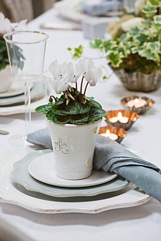 DESIGNER_JACKY_HOBBS__LONDON_CHRISTMAS_TABLE_SETTING_WITH_CANDLES_AND_WHITE_PAINTED_CONTAINER_WITH_C