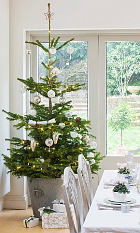 DESIGNER_JACKY_HOBBS__LONDON_DINING_ROOM_AT_CHRISTMAS__TABLE_SETTING_WITH_CANDLES_AND_WHITE_PAINTED_