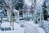 FORMAL TOWN GARDEN IN SNOW  OXFORD  WINTER: DESIGN BY LIZ NICHOLSON - ARBOUR/GAZEBO BY PATH WITH WOODEN OBELISKS  YEW HEDGING AND PINUS RADIATA