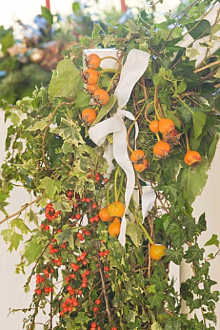 BRUERN_COTTAGES__OXFORDSHIRE_CHRISTMAS__IVY__ROSE_HIPS_AND_COTONEASTER_BERRIES_IN_STAIRCASE_DECORATI