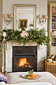 BRUERN COTTAGES  OXFORDSHIRE: CHRISTMAS - THE SITTING ROOM WITH FIREPLACE AND OTTOMAN WITH BOWL OF SATSUMAS