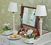 BRUERN COTTAGES  OXFORDSHIRE: CHRISTMAS - THE TWIN BEDROOM - TABLE WITH LAMPS  CYCLAMEN IN WHITE TEACUPS AND PLATE WITH MINCE PIES