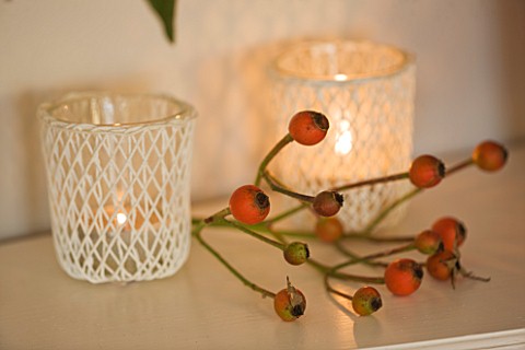 BRUERN_COTTAGES__OXFORDSHIRE_CHRISTMAS__THE_LIVING_ROOM__BERRY_DECORATION_ON_MANTELPIECE_WITH_CANDLE