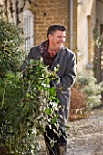 BRUERN COTTAGES  OXFORDSHIRE: CHRISTMAS - COLIN BOLAM BRINGS IN BUNDLES OF GREENERY FROM THE GARDEN