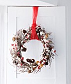 DESIGNER CAROLYN MINTY  GLOUCESTERSHIRE: TWIG WREATH WITH CONES AND BERRIES. CHRISTMAS