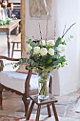 DESIGNER CAROLYN MINTY  GLOUCESTERSHIRE - VIEW THROUGH THE SITTING ROOM INTO THE DINING ROOM - VASE FILLED WITH ROSES  IVY  CATKINS AND EUCALYPTUS