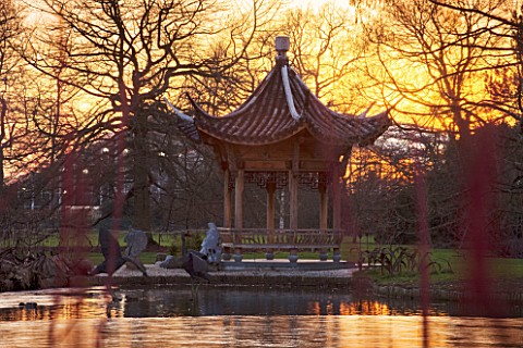 RHS_GARDEN_WISLEY__SURREY__EVENING_VIEW_OF_SEVEN_ACRES_ACROSS_THE_LAKE_TO_THE_CHINESE_PAGODA_WINTER_