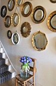 DESIGNER: KALLY ELLIS  LONDON: COLLECTION OF VINTAGE CONVEX MIRRORS IN ENTRANCE HALL