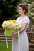 STYLING BY JACKY HOBBS  - GIRL WITH GREEN HAT BOX FILLED WITH NARCISSUS  DAFFODILS  SPRING