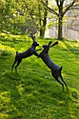CERNEY HOUSE GARDEN  GLOUCESTERSHIRE: SCULPTURE OF BOXING HARES BY MIRANDA MICHELS