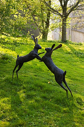 CERNEY_HOUSE_GARDEN__GLOUCESTERSHIRE_SCULPTURE_OF_BOXING_HARES_BY_MIRANDA_MICHELS