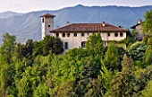 GARDEN OF PAOLO PEJRONE  ITALY: VIEW OF THE GARDEN AND HOUSE WITH MOUNTAINS BEHIND
