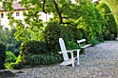 GARDEN OF PAOLO PEJRONE  ITALY: COBBLED PATH WITH WHITE WOODEN FURNITURE AND HOUSE BEHIND