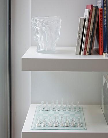 CAKE_BOY_HOUSE__LONDON_LALIQUE_VASE_AND_CHESS_SET_BENEATH_BOOKSHELF_IN_POOL_ROOM_IN_BASEMENT