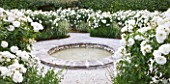 LE JARDIN DALCHIMISTE  PROVENCE  FRANCE; DESIGNERS  ERIC OSSART AND ARNAUD MAURIERES: CIRCULAR POOL SURROUNDED BY WHITE ICEBERG ROSES IN THE WHITE SQUARE