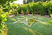 LE JARDIN DALCHIMISTE  PROVENCE  FRANCE: DESIGNERS - ERIC OSSART AND ARNAUD MAURIERES. THE RED SQUARE WITH 6 POINTED POOL AND FOUNTAIN IN LAWN