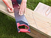 DESIGNER CLARE MATTHEWS - DECKING PROJECT - USING A PENCIL AND SAW TO CREATE A ZIG-ZAG SHAPE ON WOOD