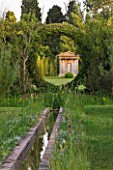 LES CONFINES  PROVENCE  FRANCE - DESIGNER: DOMINIQUE LAFOURCADE - WATER RILL LEADS OUT THROUGH AN ARCH HEDGE WITH VIEW TO FOLLY