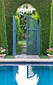 LES CONFINES  PROVENCE  FRANCE - DESIGNER: DOMINIQUE LAFOURCADE - SWIMMING POOL IN PORTUGUESE GARDEN AND VIEW THROUGH HEDGE AND BLUE TRELLIS GATE