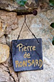 PRIEURE NOTRE-DAME DORSAN  FRANCE: ROSE  PLANT LABEL ON WALL FOR ROSA PIERRE DE RONSARD